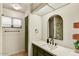 Modern bathroom featuring stylish mirror, a white countertop, sleek green cabinets, and unique tile walls at 19025 N 96Th Ave, Peoria, AZ 85382