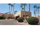 Welcoming clubhouse exterior with towering palms and manicured landscaping, set under a clear blue sky at 19025 N 96Th Ave, Peoria, AZ 85382