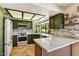 Modern kitchen with green cabinetry, white countertops, backsplash, and herringbone wood floors at 19025 N 96Th Ave, Peoria, AZ 85382