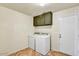 Functional laundry room with washer, dryer, overhead cabinets, and access to an exterior door at 19025 N 96Th Ave, Peoria, AZ 85382