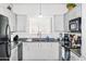 Well-lit kitchen featuring white cabinets, black appliances, and a functional layout at 1941 S Pierpont Dr # 2015, Mesa, AZ 85206