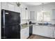 Efficient kitchen layout with a black refrigerator and white cabinets for ample storage at 1941 S Pierpont Dr # 2015, Mesa, AZ 85206