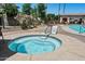 Hot tub surrounded by a paved deck, lush foliage, and access to community amenities at 1941 S Pierpont Dr # 2015, Mesa, AZ 85206