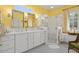 Bright bathroom featuring double sinks, decorative mirrors, and a glass shower at 19714 N Concord Dr, Surprise, AZ 85374