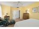 Bedroom with a ceiling fan, accent chair and ottoman, and doorway to the bathroom at 19714 N Concord Dr, Surprise, AZ 85374