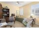 Bright bedroom with tile flooring, ceiling fan, plantation shutters and a charming wicker chair at 19714 N Concord Dr, Surprise, AZ 85374