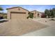 Desert home with brick-paved driveway and neutral toned facade under a sunny blue sky at 19714 N Concord Dr, Surprise, AZ 85374