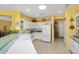 Bright kitchen with white appliances, a skylight, and tiled countertops at 19714 N Concord Dr, Surprise, AZ 85374