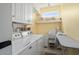 Bright laundry room with side-by-side washer and dryer, white cabinets, and a window at 19714 N Concord Dr, Surprise, AZ 85374