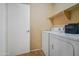 Functional laundry area with washer, dryer, shelving, and door at 2009 W Calle Del Norte Dr, Chandler, AZ 85224