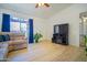 Bright living room with wood-look floors, large window, and cozy seating, creating a welcoming atmosphere at 2009 W Calle Del Norte Dr, Chandler, AZ 85224