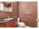 Stylish half bathroom with dark wood vanity and ornate mirror at 22063 N 77Th St, Scottsdale, AZ 85255