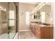 This bathroom features tiled floors, double sinks, granite countertops, and a glass shower at 22063 N 77Th St, Scottsdale, AZ 85255