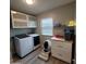 Functional laundry room with modern machines, storage cabinets, and a dedicated pet area at 2246 E Yale St, Phoenix, AZ 85006