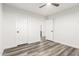 Bright bedroom with modern ceiling fan, light walls, and durable gray wood-look floors at 22500 N Greenland Park Dr, Maricopa, AZ 85139