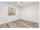 Bright bedroom featuring light walls, window view, and durable gray wood-look floors at 22500 N Greenland Park Dr, Maricopa, AZ 85139