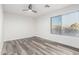 Empty bedroom with wood-look floors, a ceiling fan, and a window at 22500 N Greenland Park Dr, Maricopa, AZ 85139