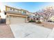 Two-story home with a two-car garage, desert landscaping, and neutral colored stucco at 22500 N Greenland Park Dr, Maricopa, AZ 85139