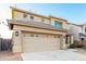 Two-story home with a two-car garage, desert landscaping, and neutral colored stucco at 22500 N Greenland Park Dr, Maricopa, AZ 85139