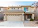 Two-story home with a two-car garage, desert landscaping, and neutral colored stucco at 22500 N Greenland Park Dr, Maricopa, AZ 85139