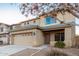 Two-story home with a two-car garage, desert landscaping, and neutral colored stucco at 22500 N Greenland Park Dr, Maricopa, AZ 85139
