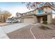 Two-story home with a two-car garage, desert landscaping, and neutral colored stucco at 22500 N Greenland Park Dr, Maricopa, AZ 85139