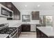 Bright kitchen features dark wood cabinets, quartz counters and stainless steel appliances at 22500 N Greenland Park Dr, Maricopa, AZ 85139