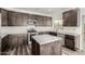 Open kitchen features dark wood cabinets, quartz counters, an island, and stainless steel appliances at 22500 N Greenland Park Dr, Maricopa, AZ 85139