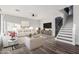 Bright living room features modern decor, hardwood floors, and a staircase leading to the upper level at 22500 N Greenland Park Dr, Maricopa, AZ 85139
