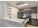 Stylish kitchen featuring open shelving, black appliances, and a quartz breakfast bar at 2301 E University Dr # 256, Mesa, AZ 85213