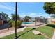 Community pool area fenced in with a manicured lawn and landscaping at 2301 E University Dr # 256, Mesa, AZ 85213