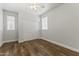 Bedroom featuring hardwood floors, a closet, and natural light from two windows at 2363 W Dusty Wren Dr, Phoenix, AZ 85085