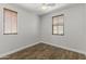 A simple bedroom with hardwood floors, white walls, and natural light from two windows at 2363 W Dusty Wren Dr, Phoenix, AZ 85085