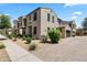 Charming stucco home with a balcony, well-maintained landscaping, and a brick driveway leading to an attached garage at 2363 W Dusty Wren Dr, Phoenix, AZ 85085