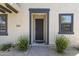 Inviting front entrance featuring a sleek dark door, sidelight window, and low-maintenance desert landscaping at 2363 W Dusty Wren Dr, Phoenix, AZ 85085
