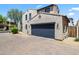 A view of the attached garage with a blue door and the house number above, complemented by a brick driveway at 2363 W Dusty Wren Dr, Phoenix, AZ 85085