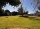 Green backyard with mature trees and a block wall in the distance, providing privacy at 25722 S 179Th St, Queen Creek, AZ 85142
