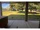 View of the spacious backyard from the covered patio, featuring mature trees and green grass at 25722 S 179Th St, Queen Creek, AZ 85142