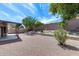 Backyard landscaping with rock groundcover, mature trees, shrubs, and a covered patio at 2730 E Desert Trumpet Rd, Phoenix, AZ 85048