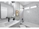 Modern bathroom featuring white marble-look tile, a sleek vanity, and a shower-tub combination at 2730 E Desert Trumpet Rd, Phoenix, AZ 85048