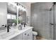 Stylish bathroom featuring double sinks, modern lighting, gray tile, and a glass-enclosed shower at 2730 E Desert Trumpet Rd, Phoenix, AZ 85048