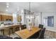 Spacious dining area open to a kitchen with modern lighting, an island with barstools, and light, wood-look flooring at 2730 E Desert Trumpet Rd, Phoenix, AZ 85048