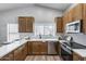 Updated kitchen featuring wood cabinets, stainless steel appliances, a white counter, and a modern sink at 2730 E Desert Trumpet Rd, Phoenix, AZ 85048