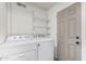 Bright laundry area with white appliances and shelving for organized storage at 3030 S Rogers --, Mesa, AZ 85202