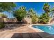 Backyard pool with a red stone patio, palm trees, lush plantings and a privacy wall at 3030 S Rogers --, Mesa, AZ 85202