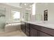 Bathroom with double vanity, soaking tub, walk-in shower, and natural light at 3128 E Tina Dr, Phoenix, AZ 85050