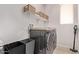 Well-organized laundry room with modern washer and dryer, storage shelves and sink at 3128 E Tina Dr, Phoenix, AZ 85050