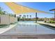 Community pool featuring sunshades, pool loungers, palm trees, and manicured landscaping at 3128 E Tina Dr, Phoenix, AZ 85050