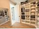 Spacious walk-in closet with custom shelving, drawers, and a full-length mirror at 3128 E Tina Dr, Phoenix, AZ 85050
