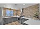 Updated kitchen showcasing brick backsplash, stainless steel appliances, and gray cabinets at 3345 E University Dr # 47, Mesa, AZ 85213
